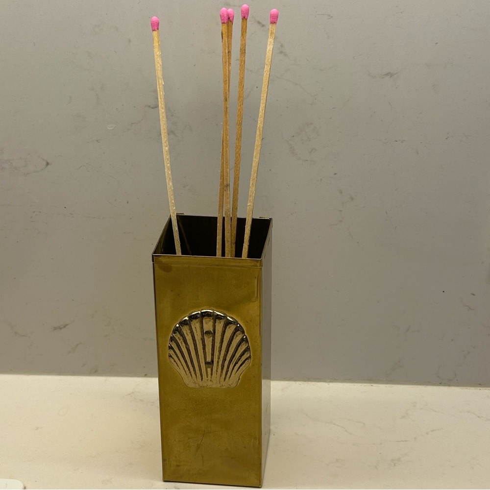 Vintage brass embossed shell motif match holder and striker .